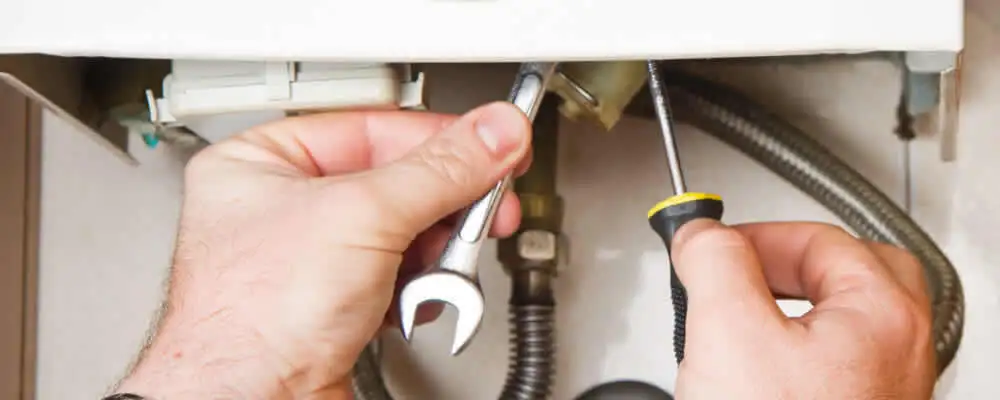 Boiler repair technician tightening pipe fittings and connections in Detroit, MI