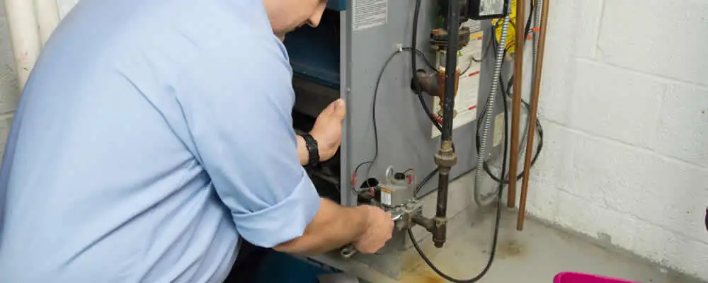 Furnace repair technician inspecting and servicing a home heating system in Detroit, MI