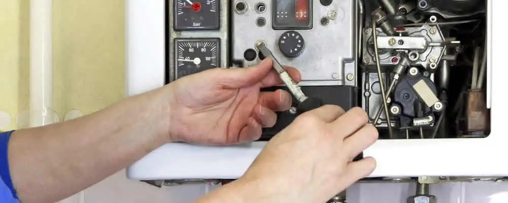 Heating repair technician adjusting boiler controls and components in Detroit, MI