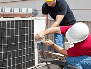 HVAC technicians repairing an outdoor AC unit on a rooftop in Detroit, MI