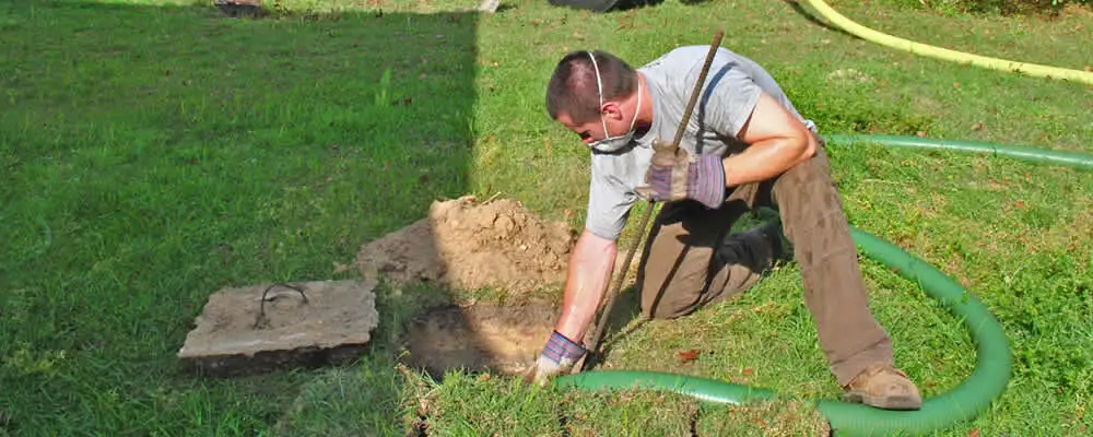 Septic pumping technician servicing a residential septic tank in Detroit, MI