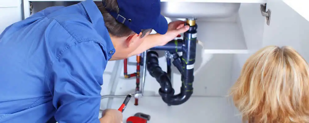 Plumber repairing under-sink drain pipes and fittings in Detroit, MI